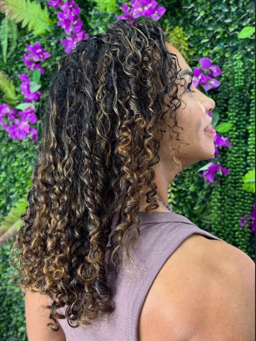 Cabelo cacheado com mechas douradas, visto de perfil